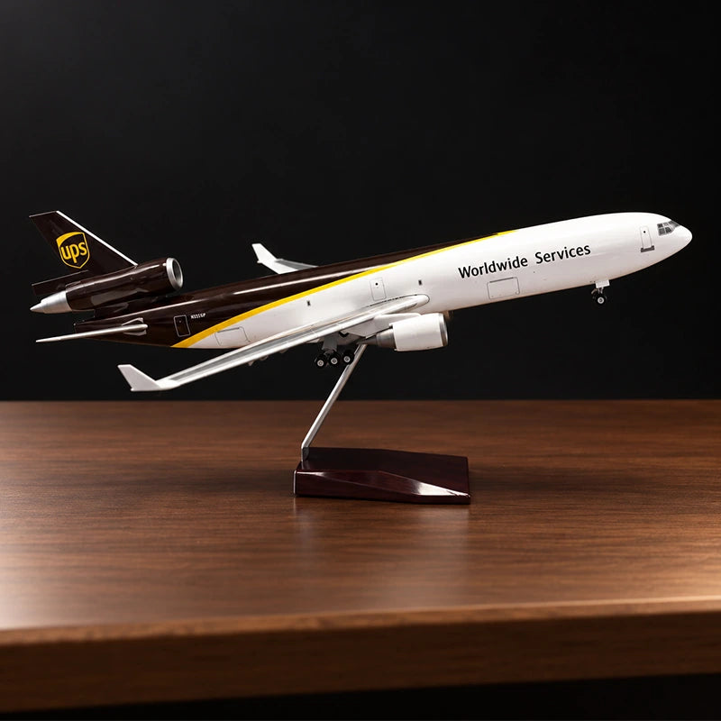 Maquette de l’avion cargo McDonnell Douglas MD-11F UPS au 1:130 avec livrée UPS détaillée, sur un support posé sur une table de salon.