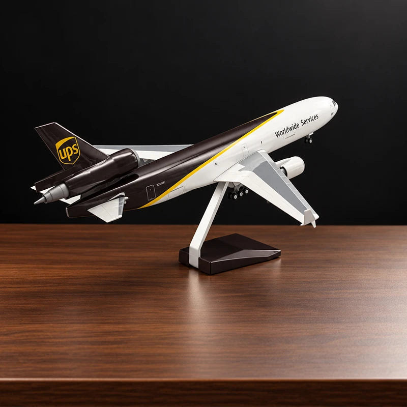 Maquette de l’avion cargo McDonnell Douglas MD-11F UPS au 1:130 avec livrée UPS détaillée, sur un support posé sur une table de salon.