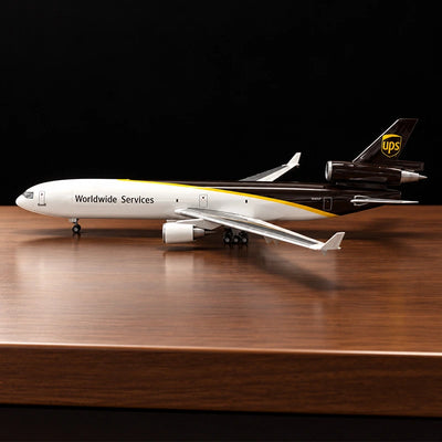 Maquette de l’avion cargo McDonnell Douglas MD-11F UPS au 1:130 avec livrée UPS détaillée, sur un support posé sur une table de salon.