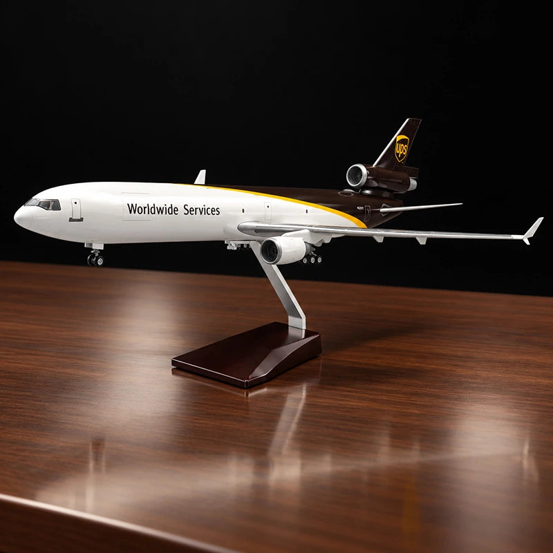 Maquette de l’avion cargo McDonnell Douglas MD-11F UPS au 1:130 avec livrée UPS détaillée, sur un support posé sur une table de salon.