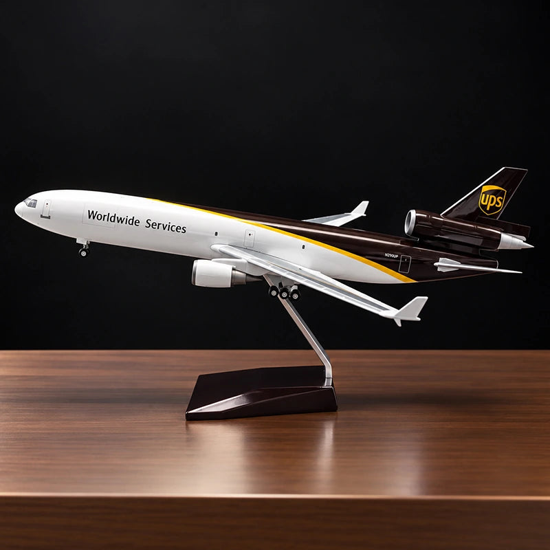 Maquette de l’avion cargo McDonnell Douglas MD-11F UPS au 1:130 avec livrée UPS détaillée, sur un support posé sur une table de salon.